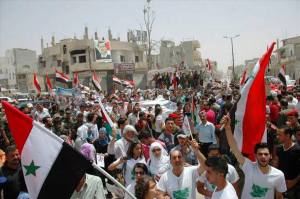 Demo warga kota Al Qusayr yang gembira setelah kota mereka dibebaskan oleh tentara Suriah (hampir dua tahun kota ini dijadikan basis suplai senjata dan pasukan dari luar negeri oleh para “mujahidin”), 2013